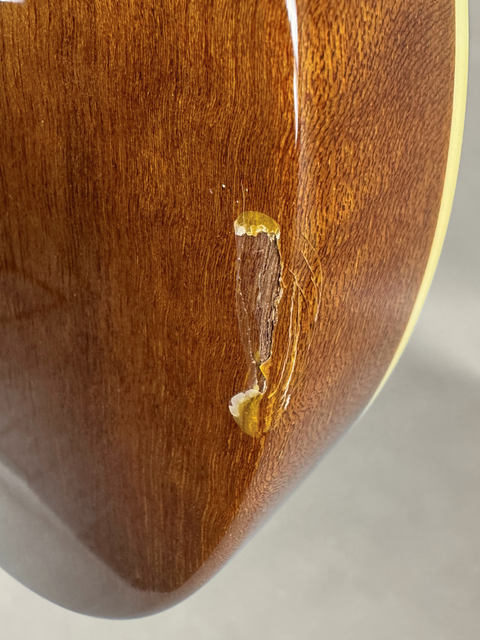 A ding on the back body edge exposing the wood